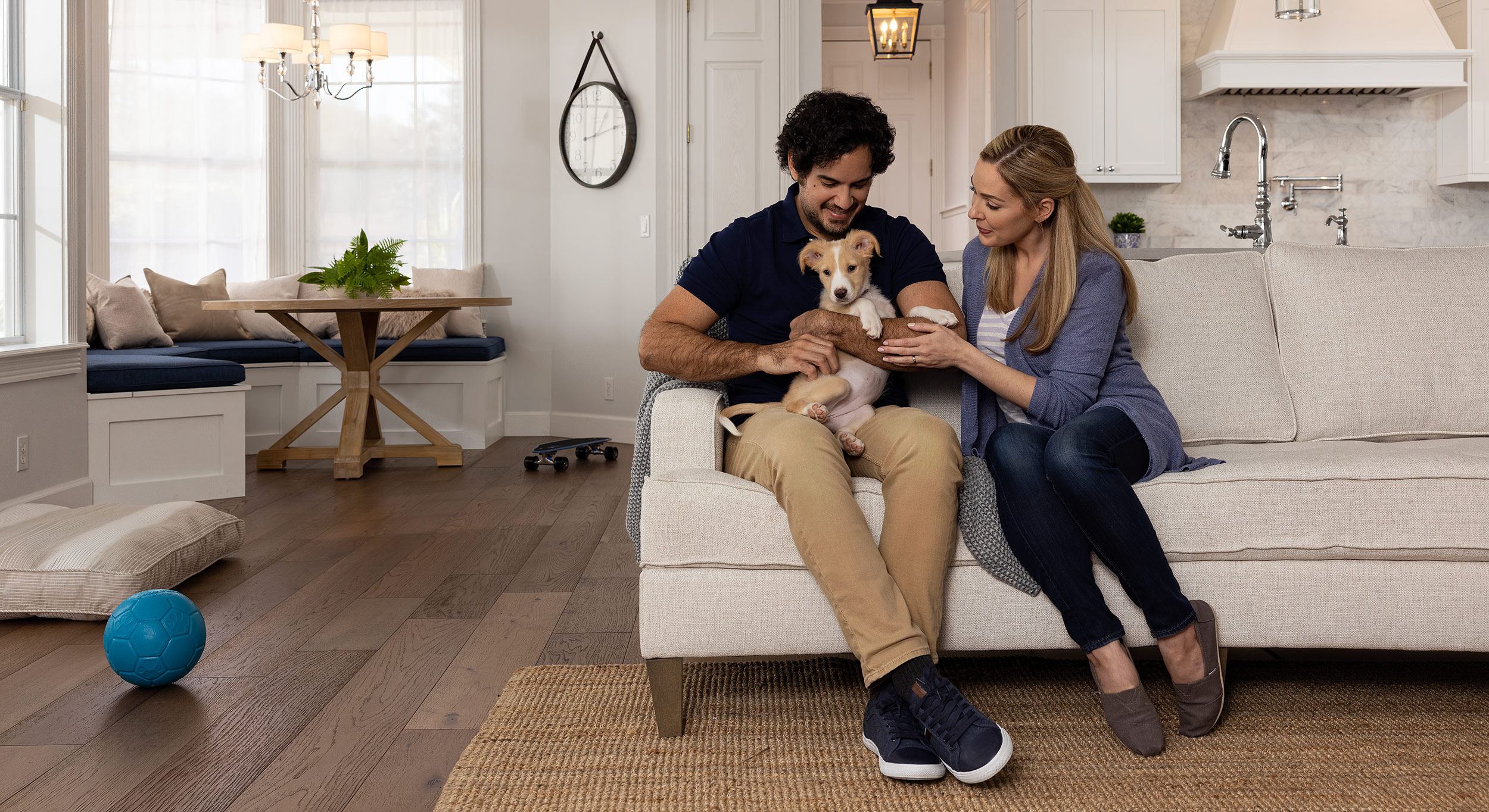 couple petting puppy on couch for a Seresto brand ad. 