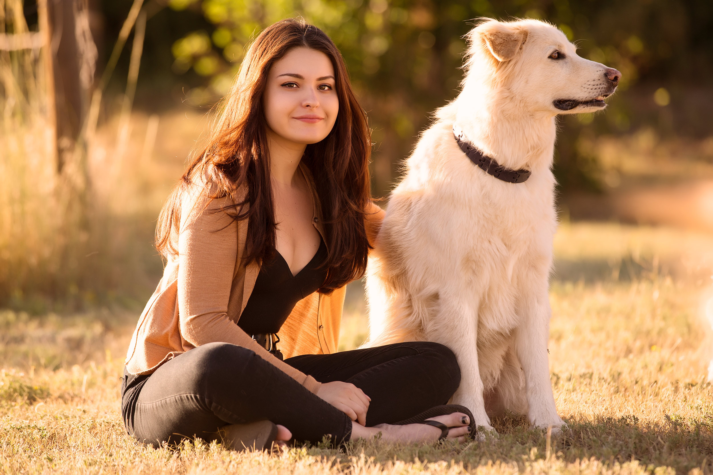 Portrait of young female sitting next to an irish setter