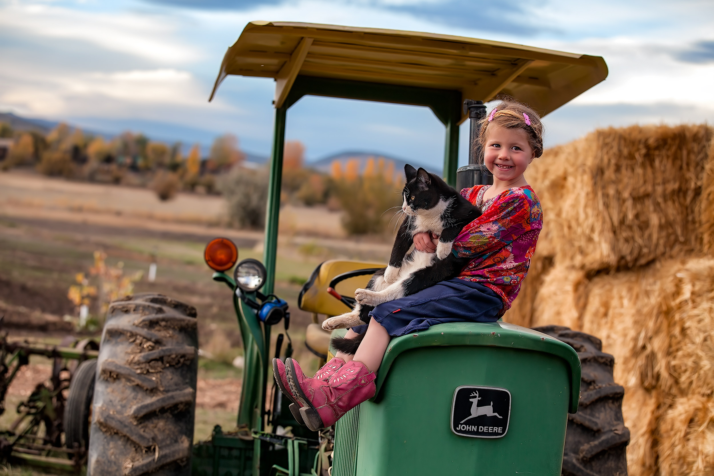 Agriculture Photography young girl sitting on tractor with her pet cat