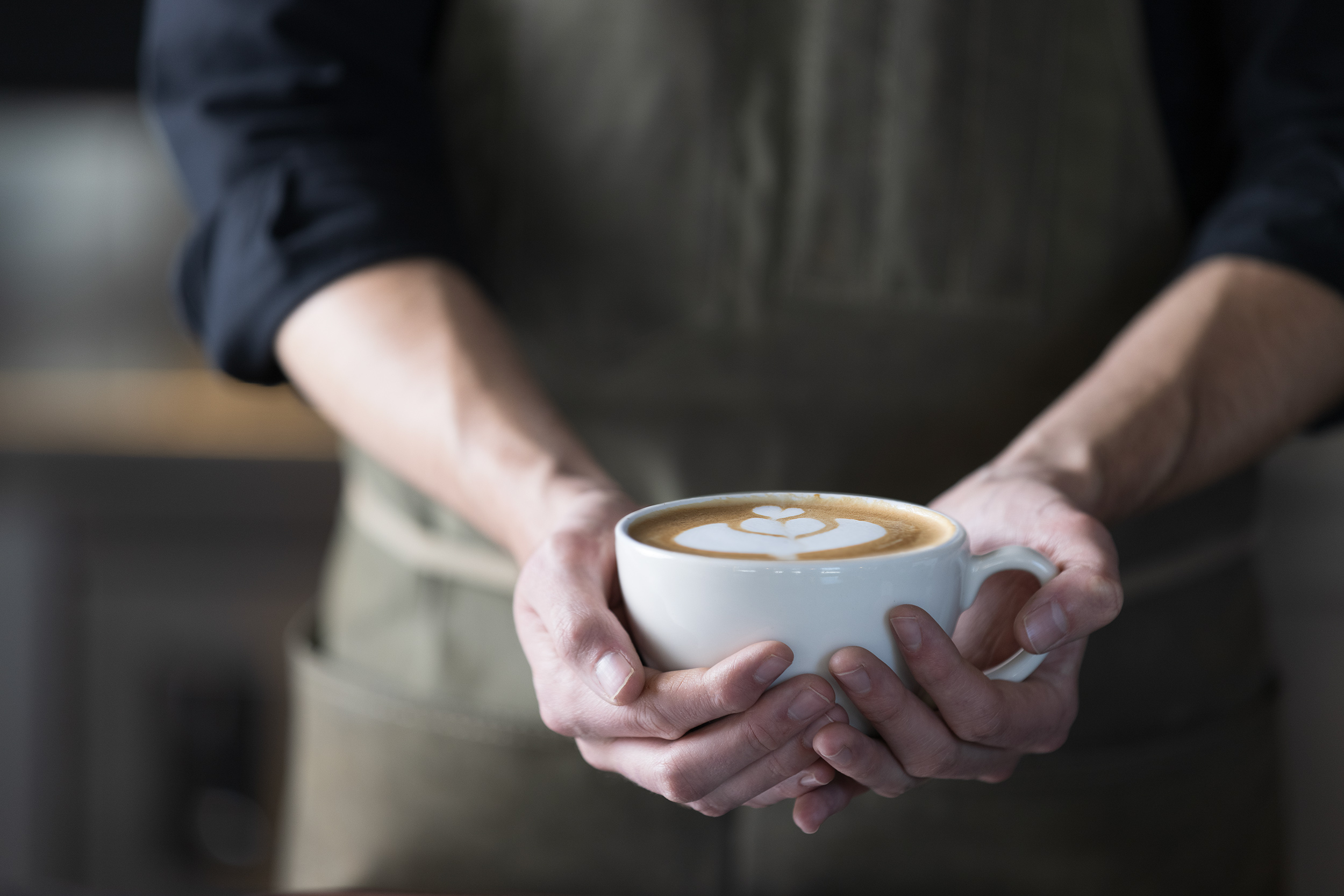 Barista holding creative latte for Devils Thumb Ranch