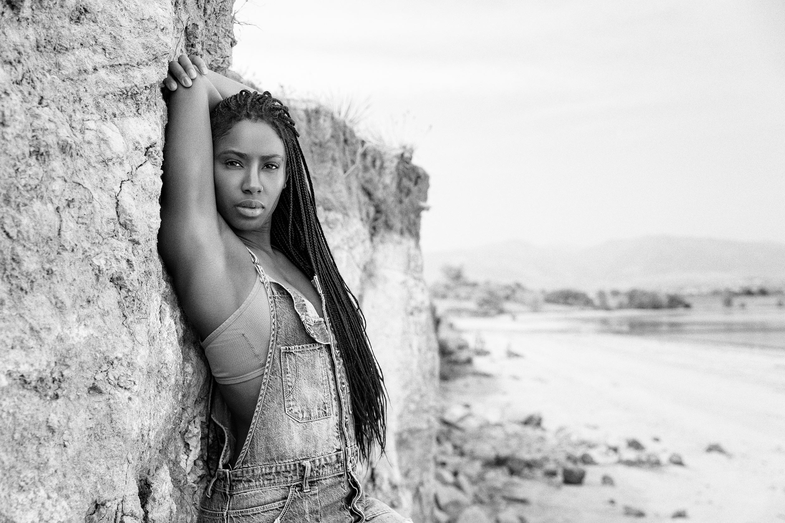 Black and white of a female model in overalls near a lake