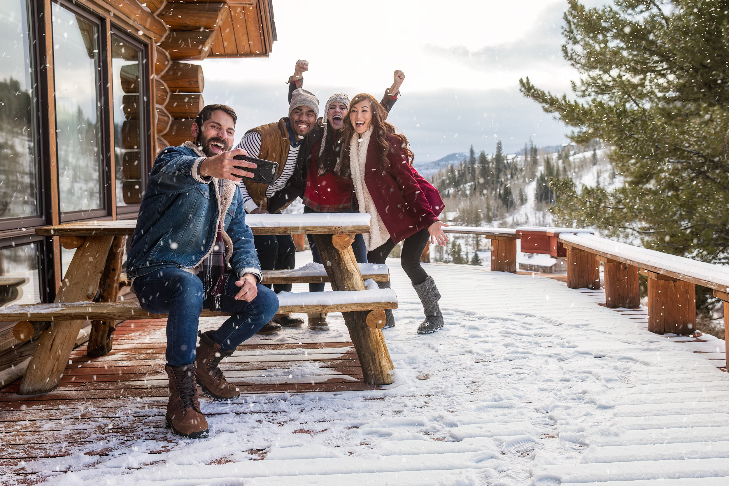 Friends taking a selfie outside on a snow covered porch for The Travel Channel