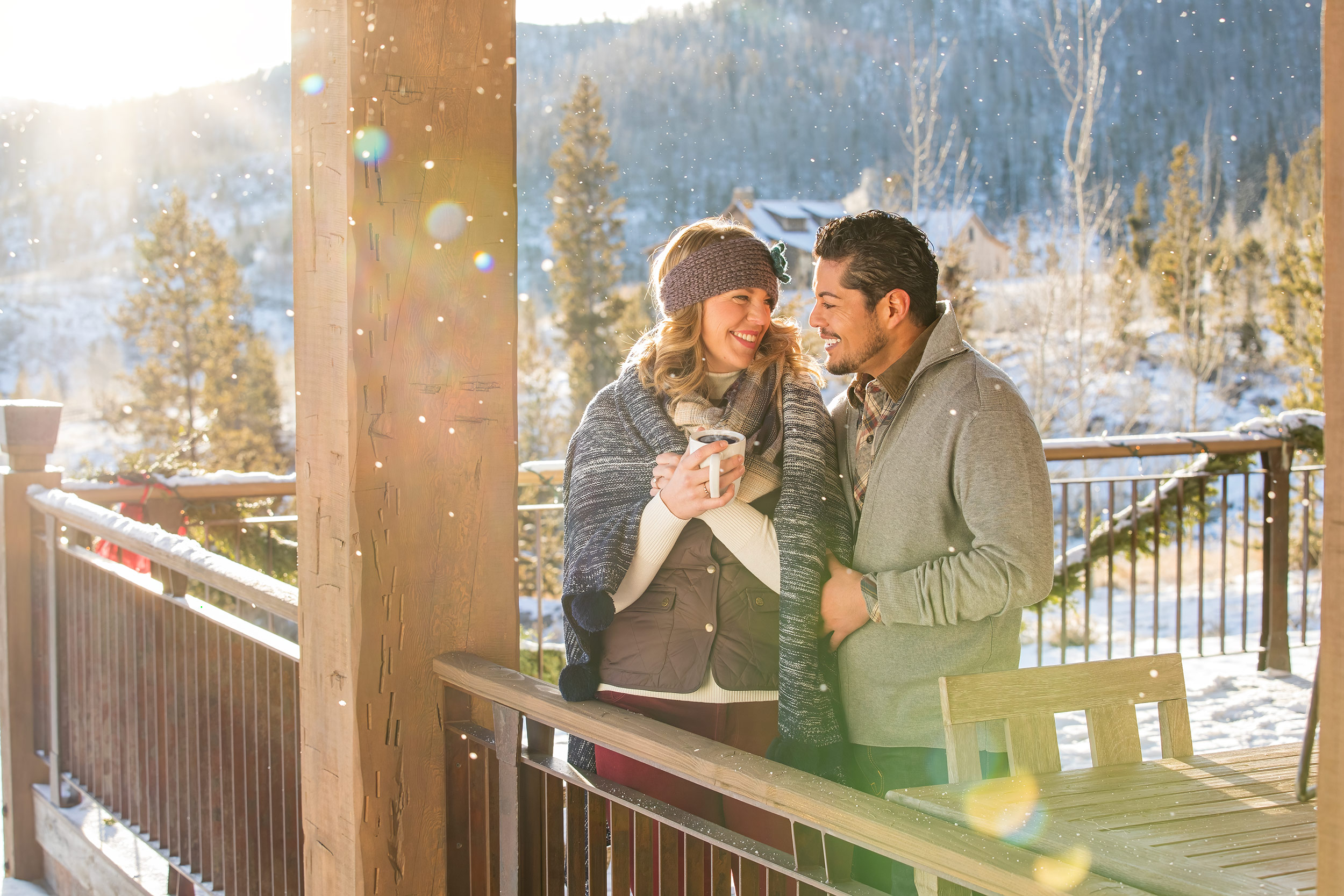 Lifestyle photography, couple drinking coffee outside on a porch in snow