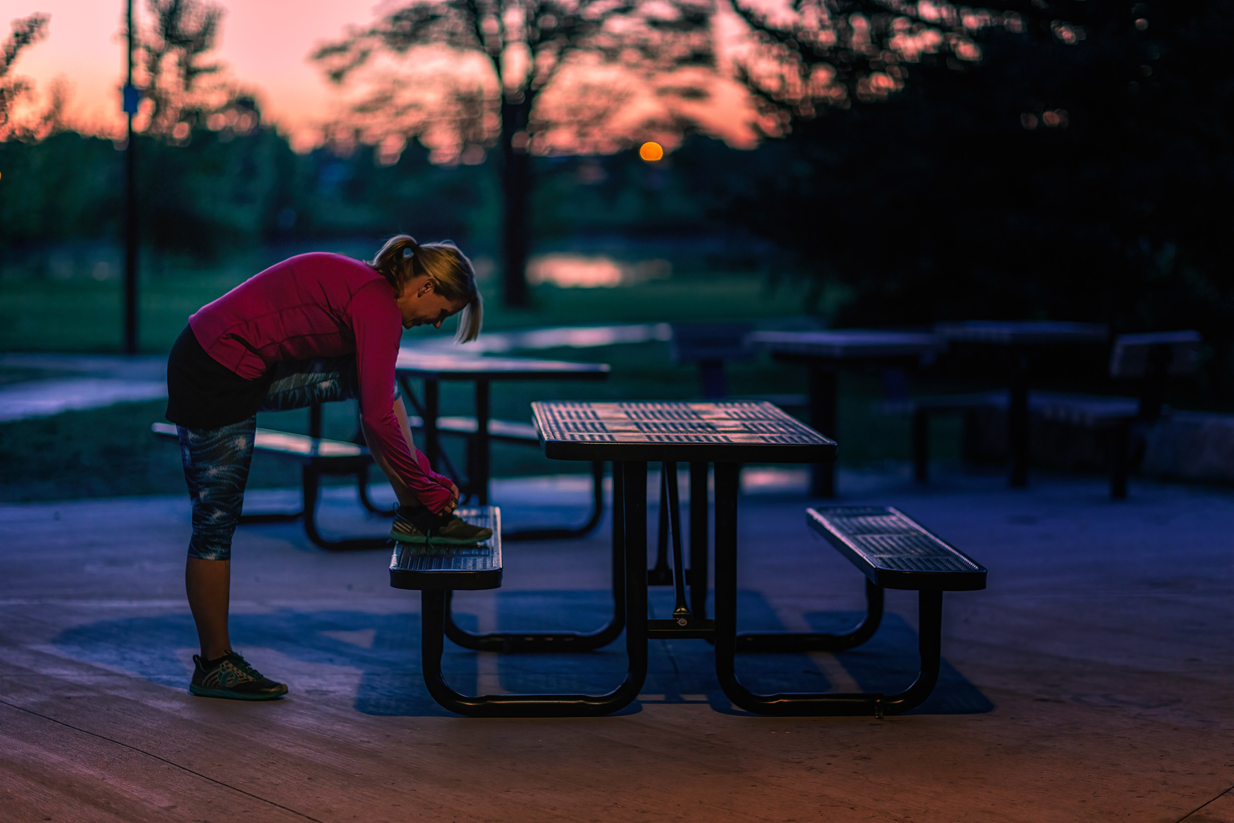 Woman Trail Runner tying shoes at sunrise for Skirt Sports
